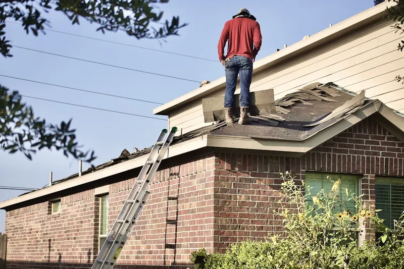 Professional roofer working on a residential roof in Shore Hills